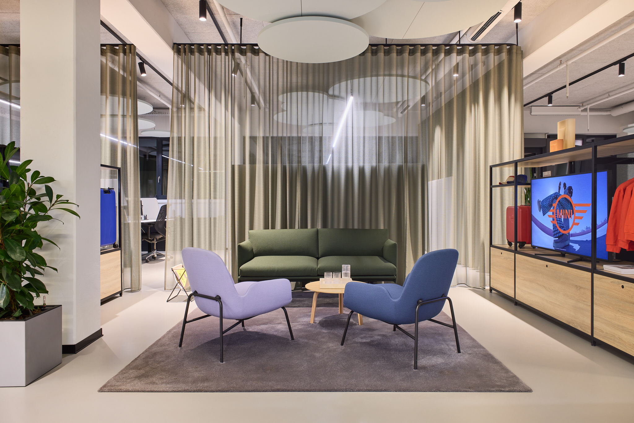 Lounge-Sitzgelegenheit mit Vorhängen, ruhige Atmosphäre und klare Markenarchitektur für MINI.