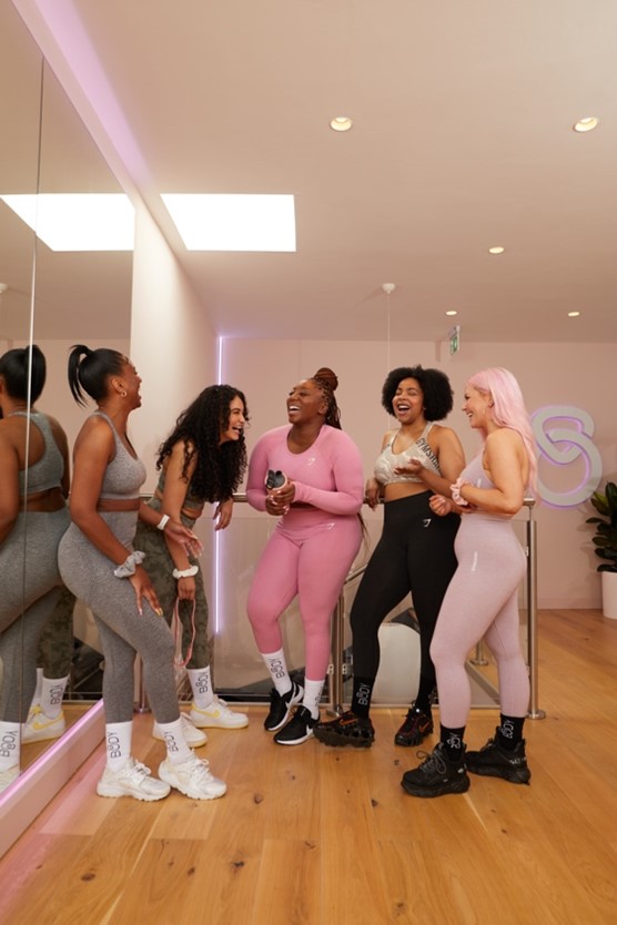 A photo of Ciara in two piece gym wear with a light grey background. In the top left corner reads “Meet Ciara”