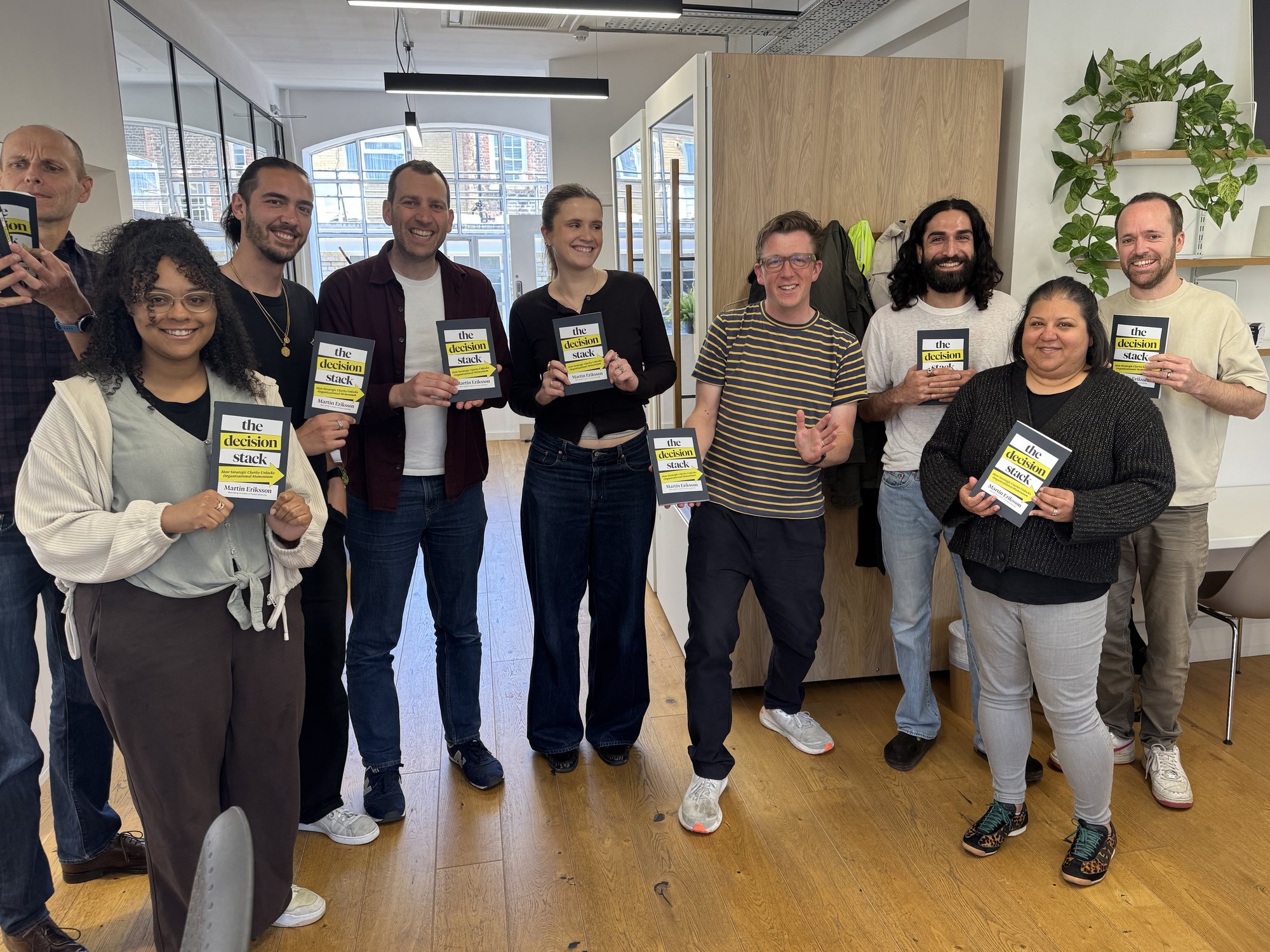 The Loomery team in the office, each holding a copy of The Decision Stack