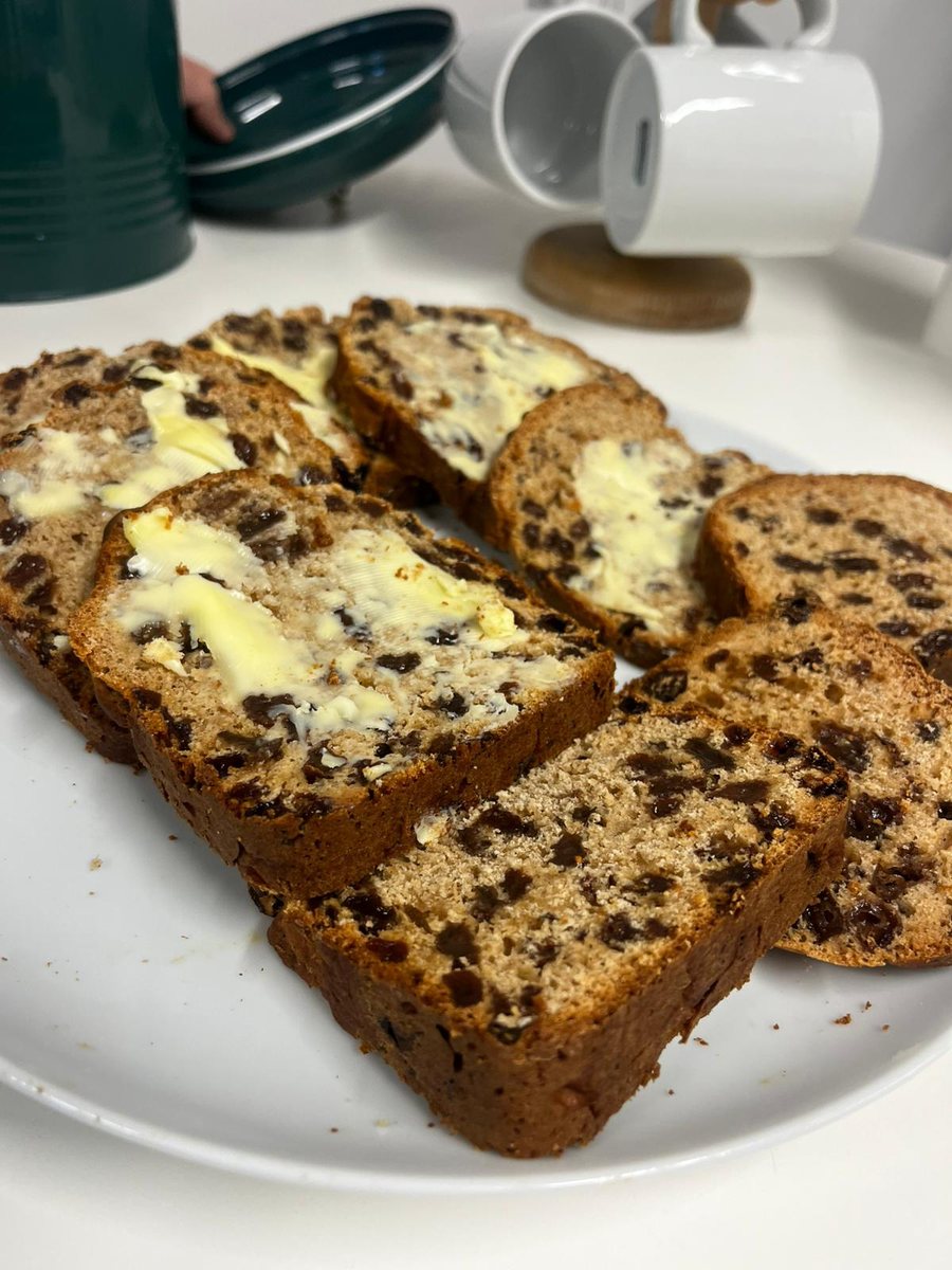 Slices of buttered tea loaf on a plate in the office kitchen