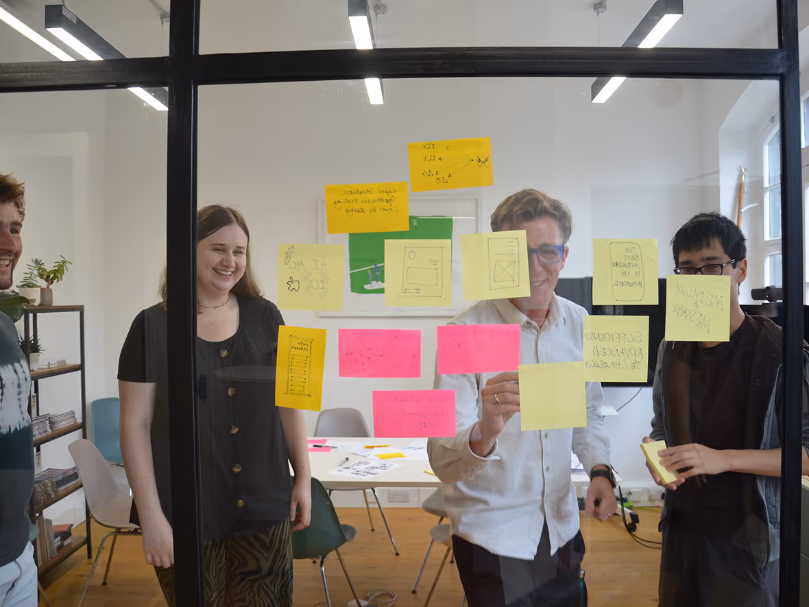 The Loomery team in the London studio, mapping ideas on sticky notes on a glass wall