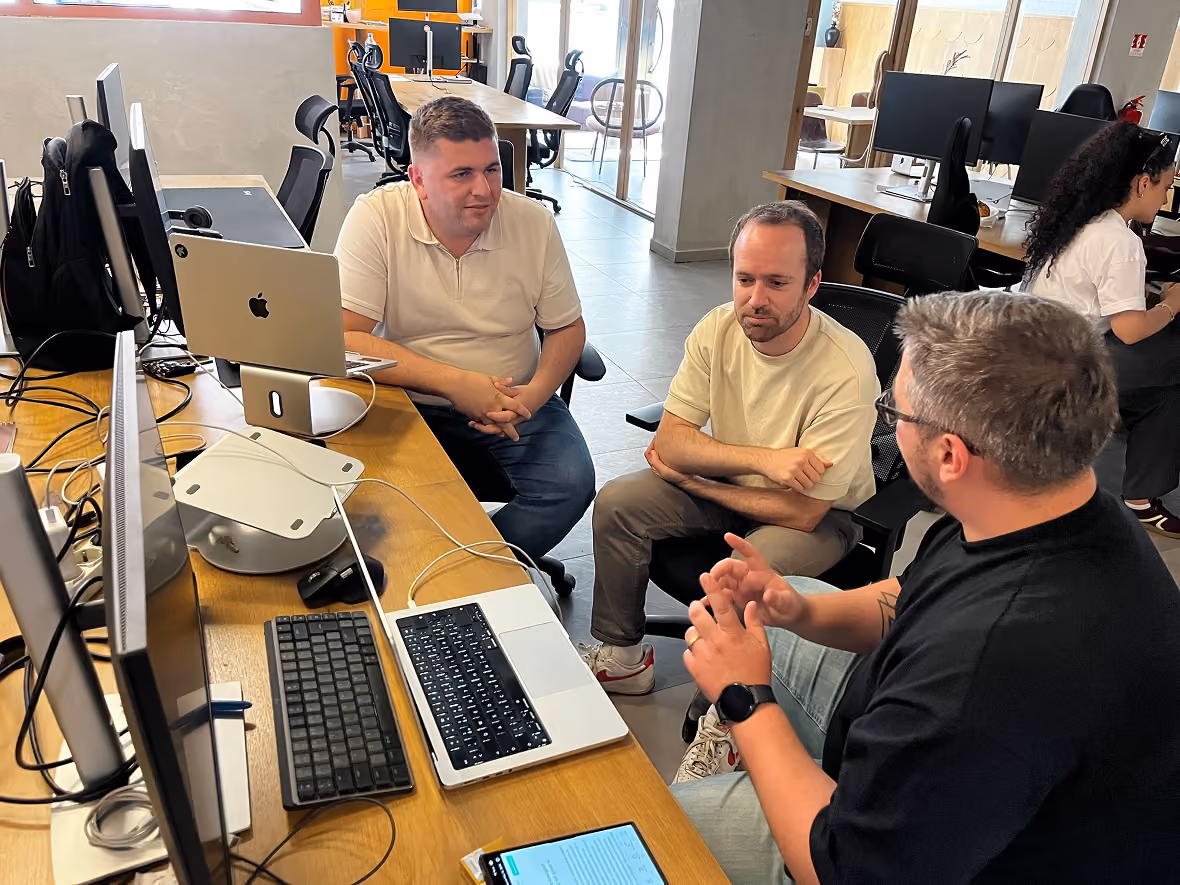 Engineers talking around a desk in the Prishtina office