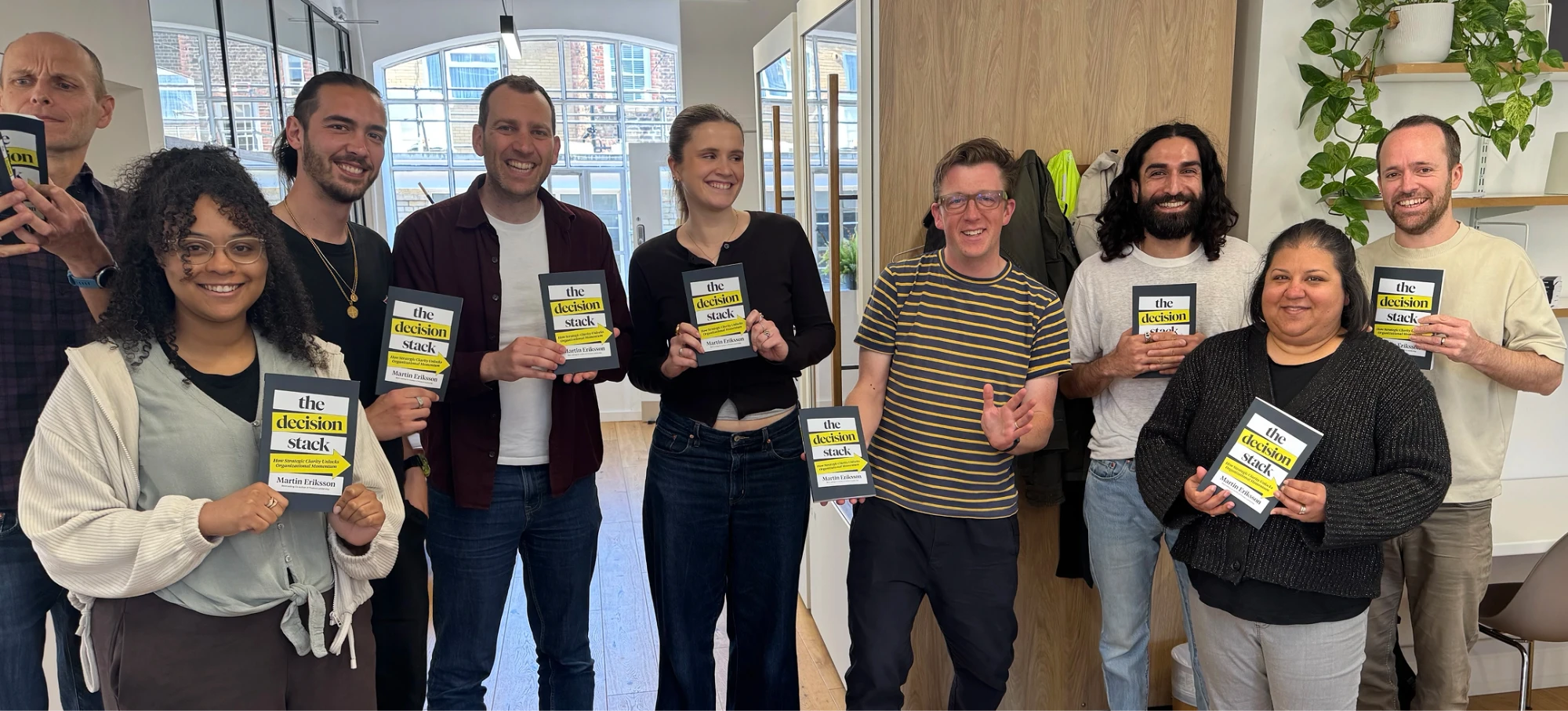 The Loomery team in the office, each holding a copy of The Decision Stack