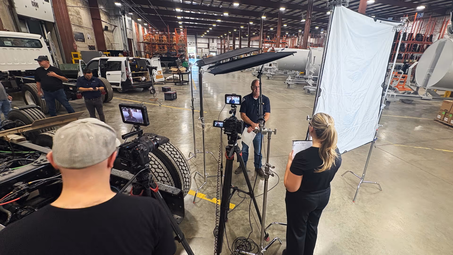 behind the scenes photo of a filming session in a manufacturing warehouse