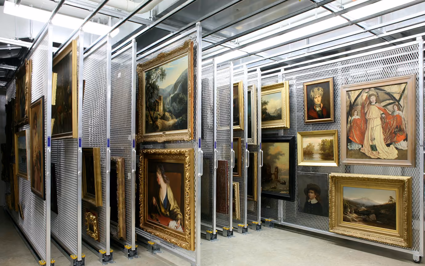 A well-organized museum storage area featuring paintings in ornate frames on sliding metal racks. Image courtesy of the Allen Memorial Art Museum.