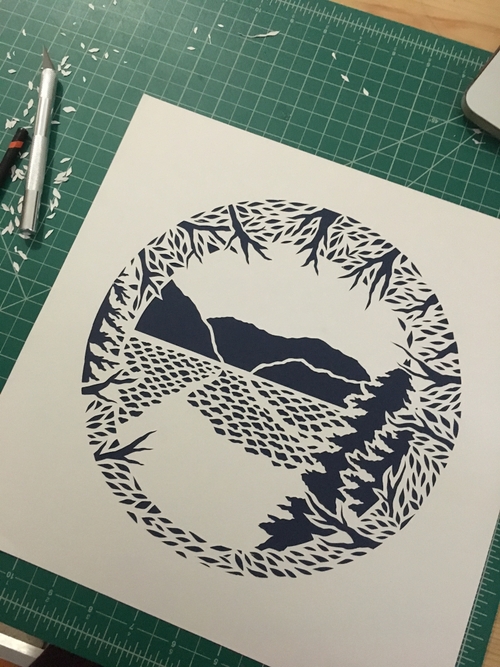 ocean and mountain scene by cutting forms out of one paper
