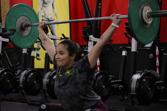 A young girl with weight on her back
