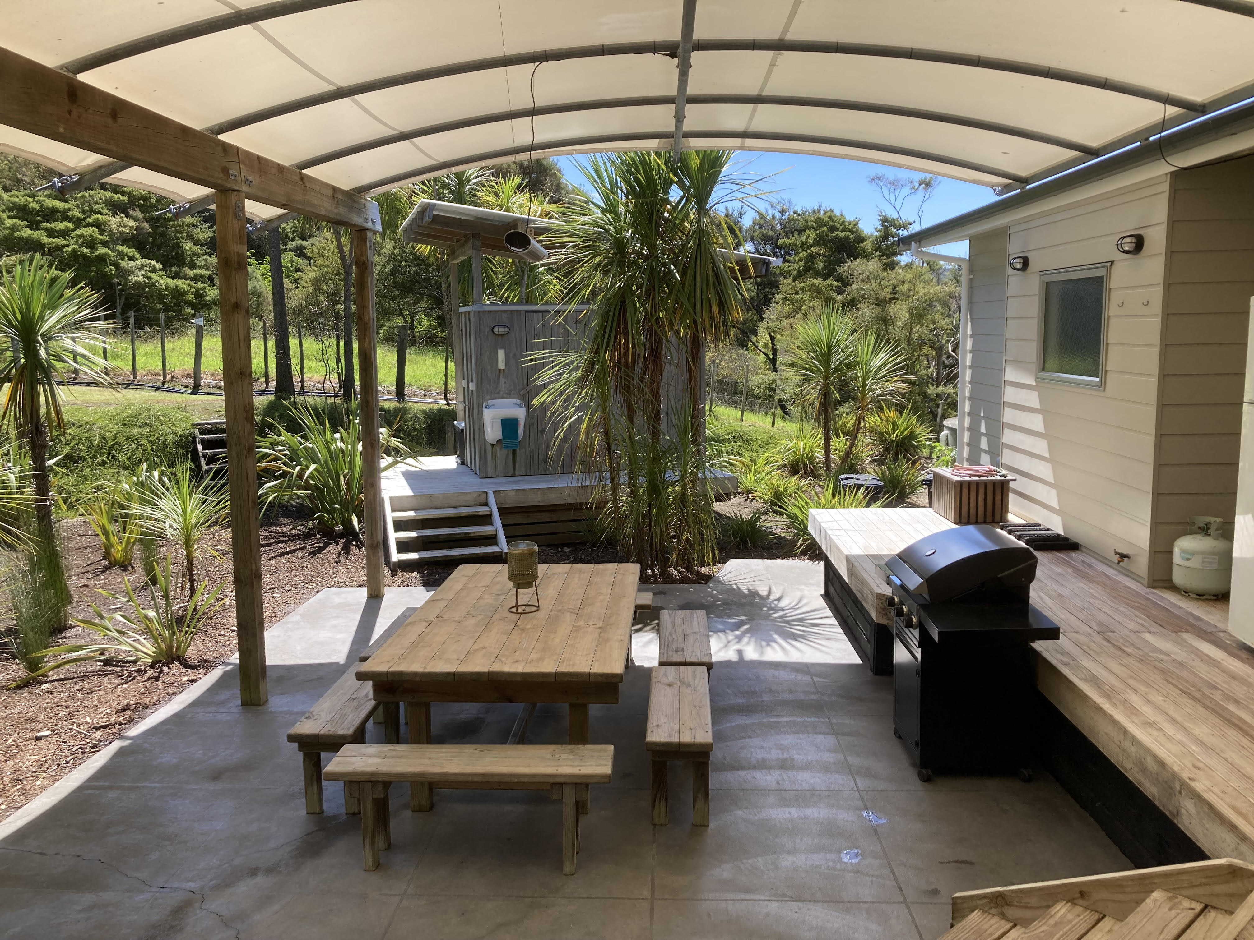 Covered outdoor dining table and barbecue at the holiday home
