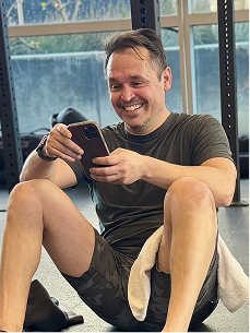 A Gymparty member sitting on the floor checking his phone
