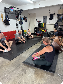Members stretching on mats in a home gym