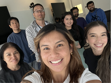 A workplace team smiling together in a group selfie