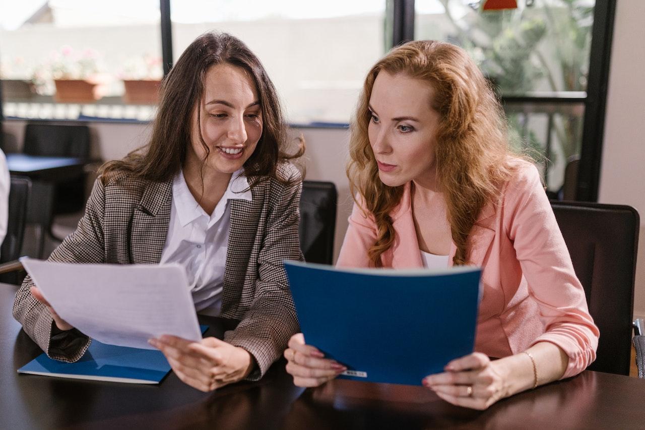A photo of two professionals looking at documents together.