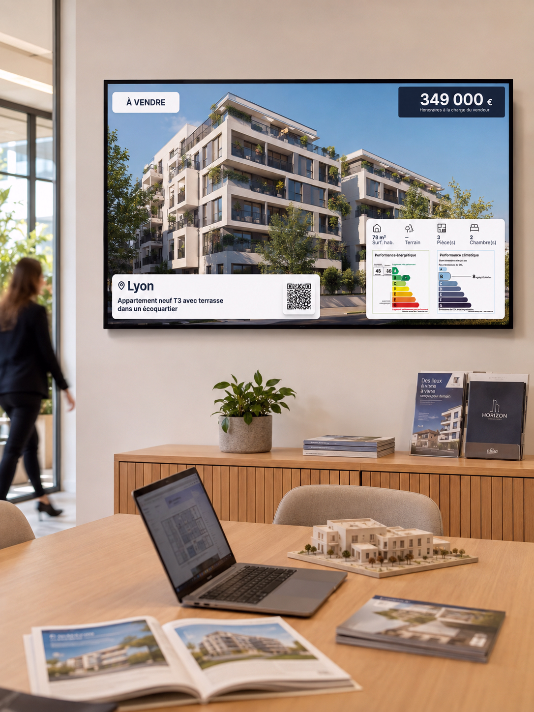 Écran d’affichage dynamique installé dans les bureaux d’un promoteur immobilier, présentant un programme immobilier neuf à Lyon avec prix, caractéristiques du logement, QR code et diagnostics énergétiques.
