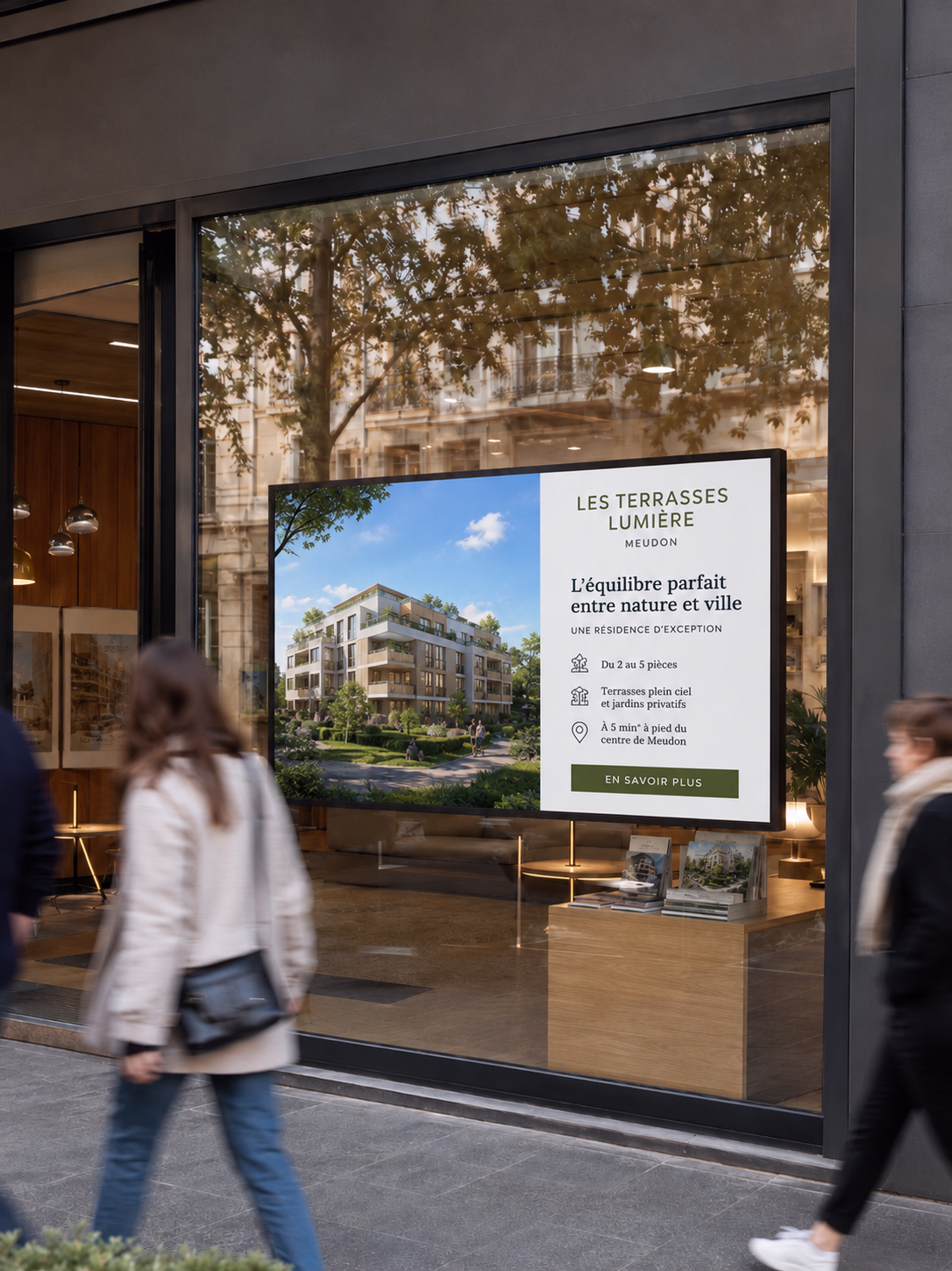 Écran d’affichage dynamique installé dans la vitrine de bureaux d’un promoteur immobilier, présentant le programme fictif « Les Terrasses Lumière » à Meudon, avec visuel de la résidence, arguments commerciaux et passants flous en mouvement devant la vitrine.