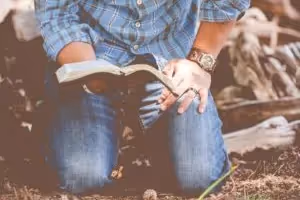 Men's Ministry - man kneeling with Bible