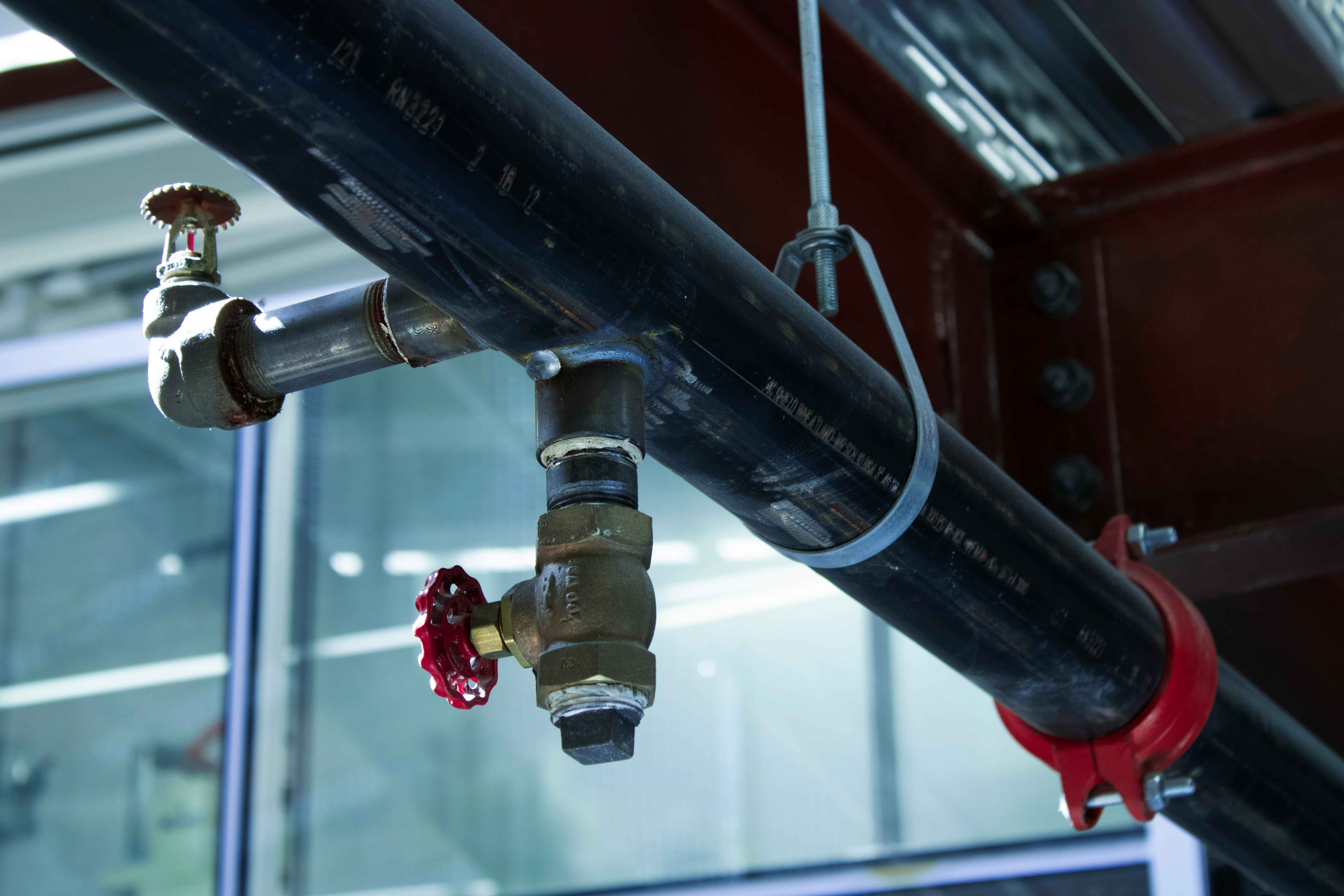 Close-up of metal plumbing pipes with a control valve