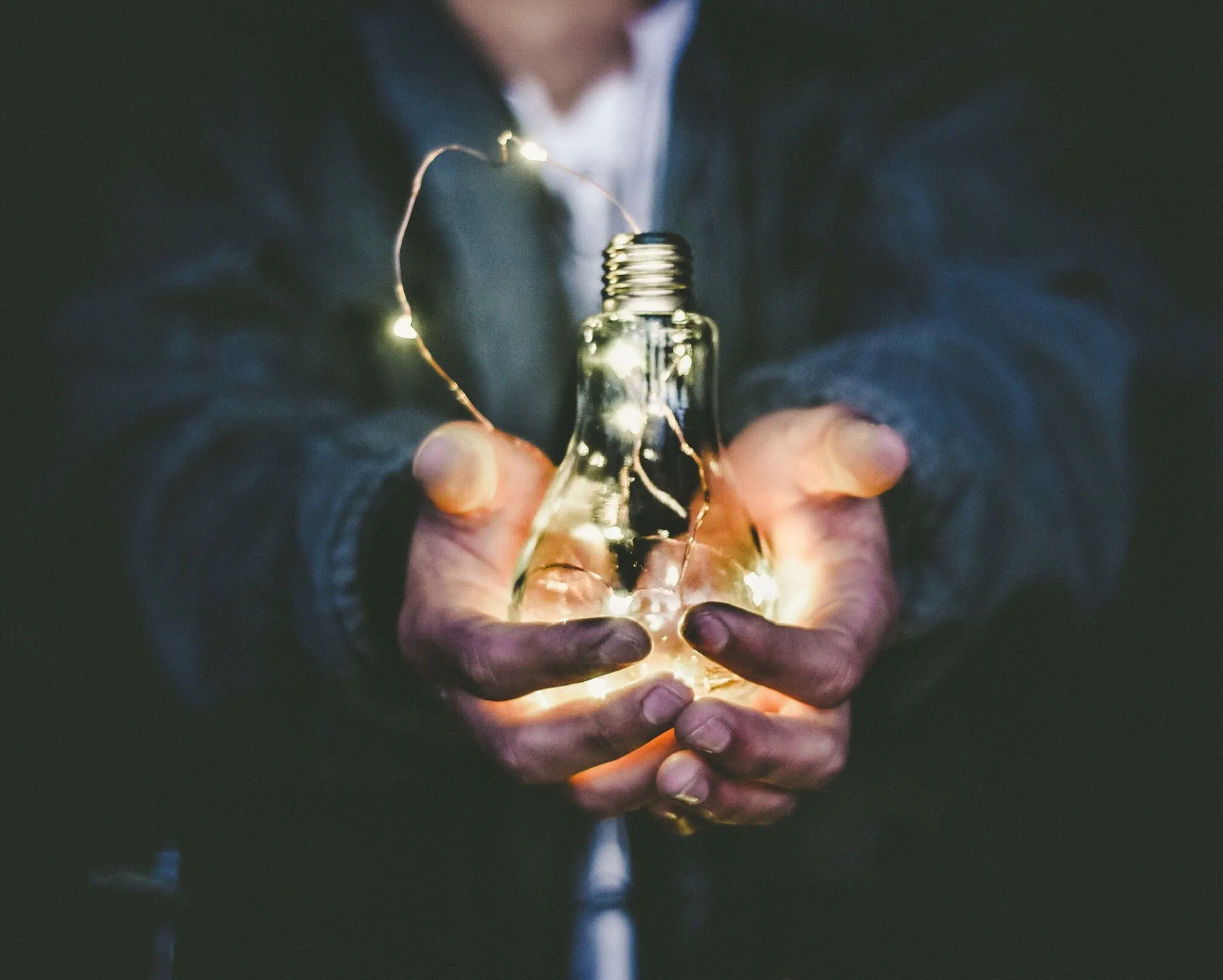 Hands holding a lightbulb