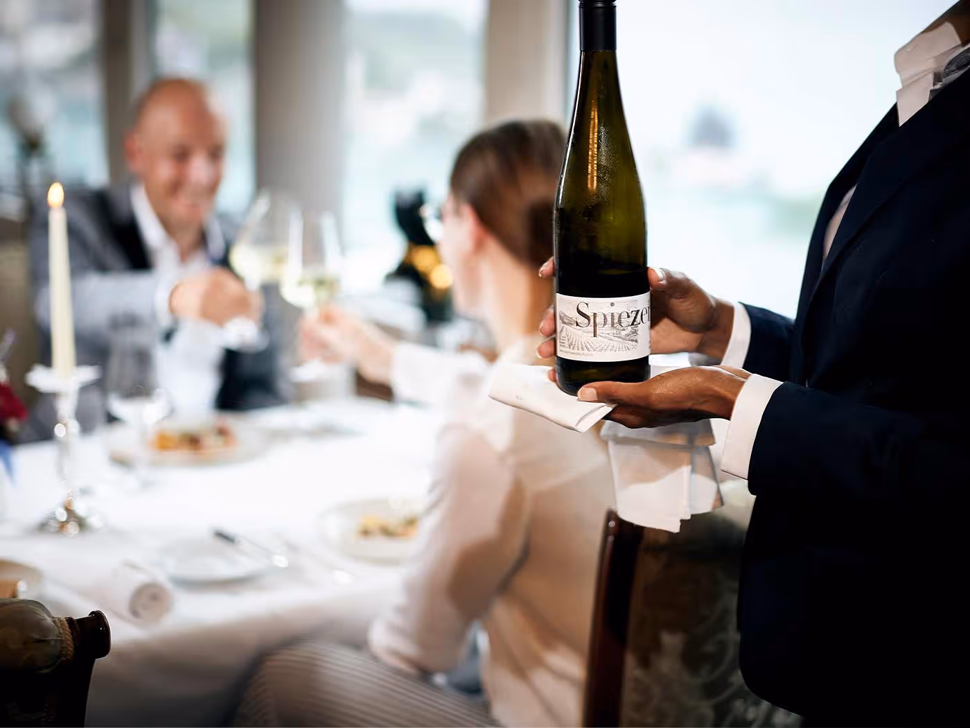 Restaurantbedienung bringt Flasche Wein an den Tisch