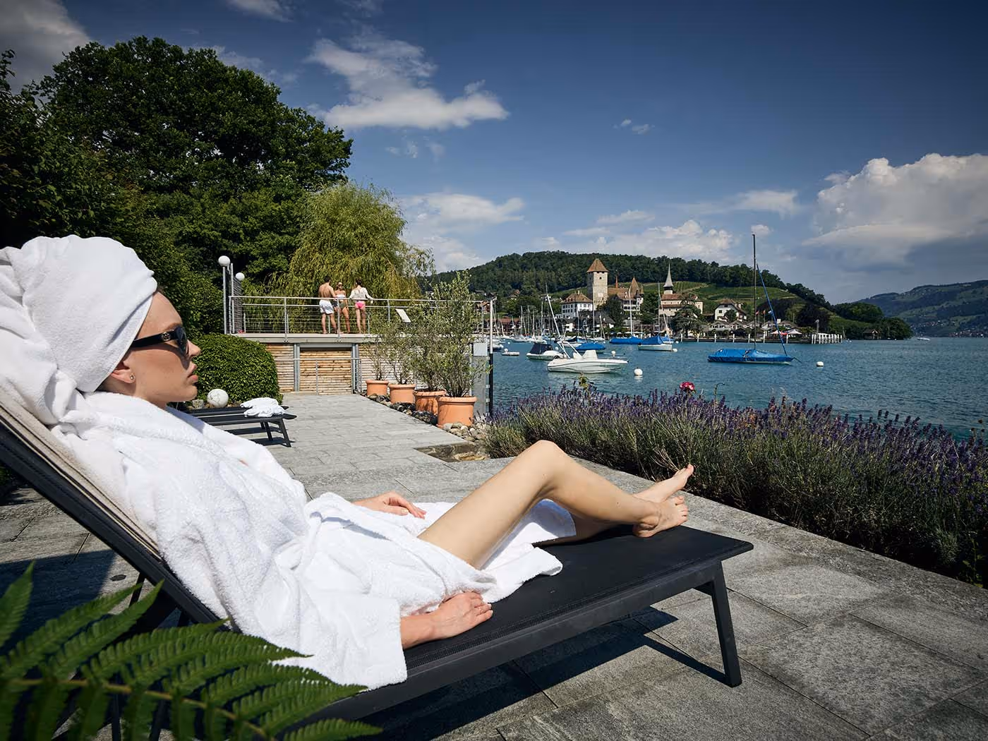 Woman in a bathrobe on a deck chair in a private lido