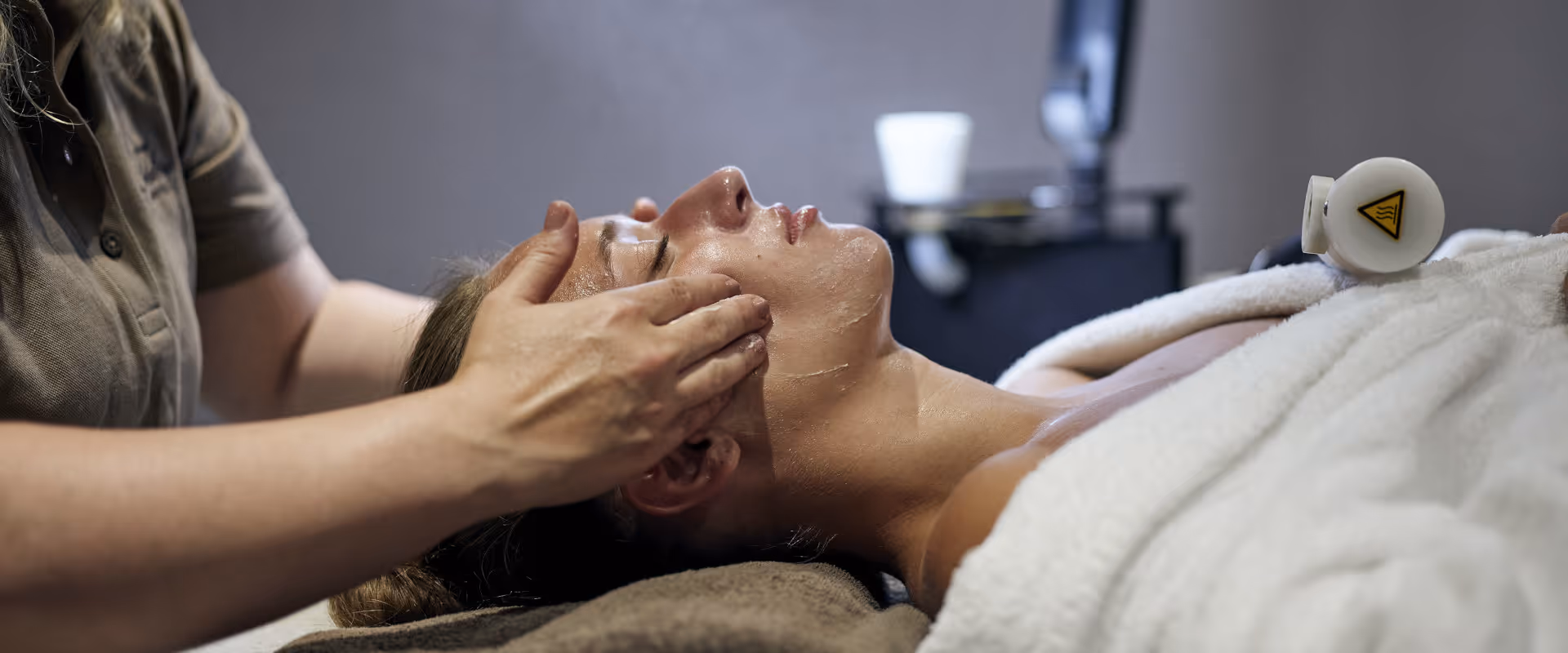 Soin du visage d'une femme par une esthéticienne