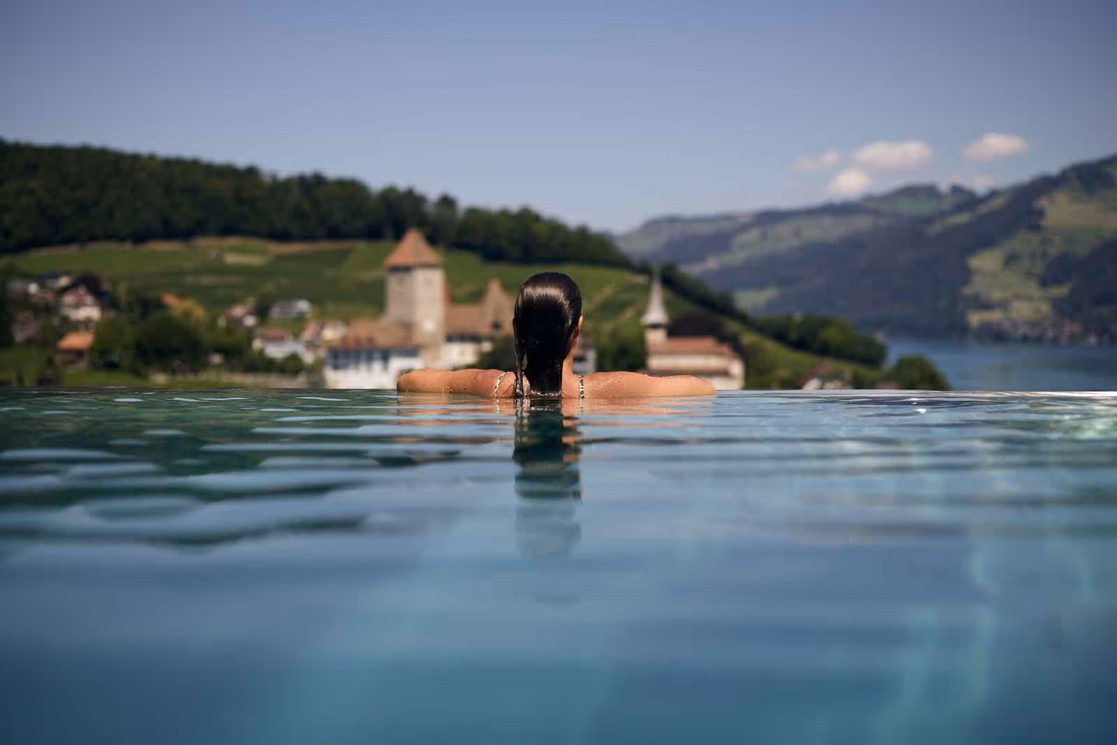 Femme dans la piscine à débordement avec vue sur Spiez