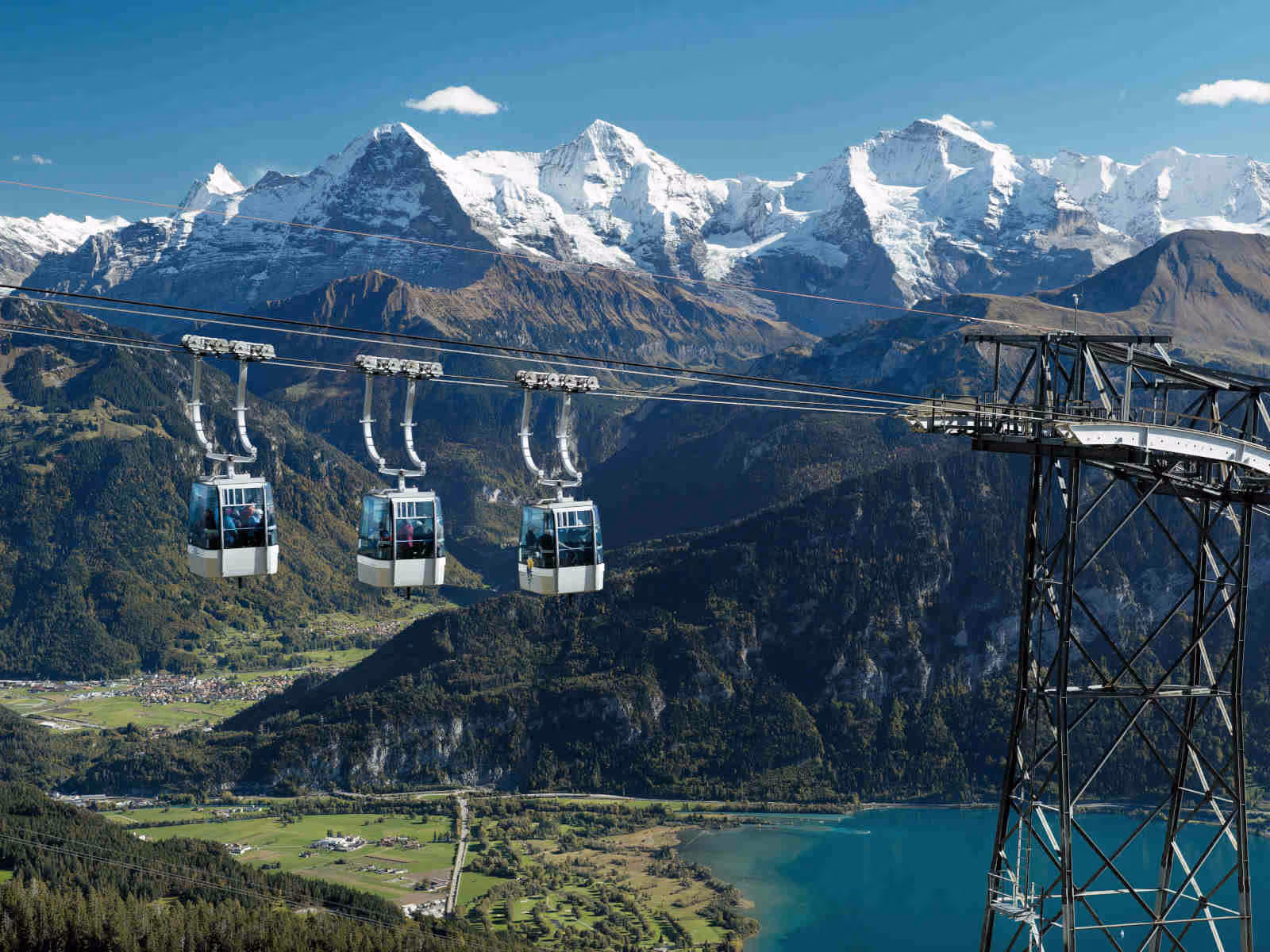 Three Niederhorn cable car gondolas with a view of the lake