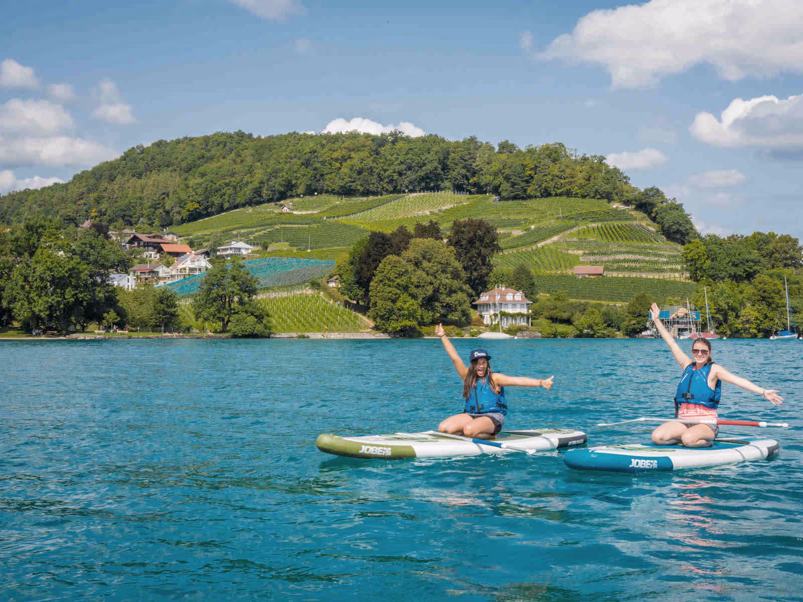 2 women on stand up paddles on Lake Thun