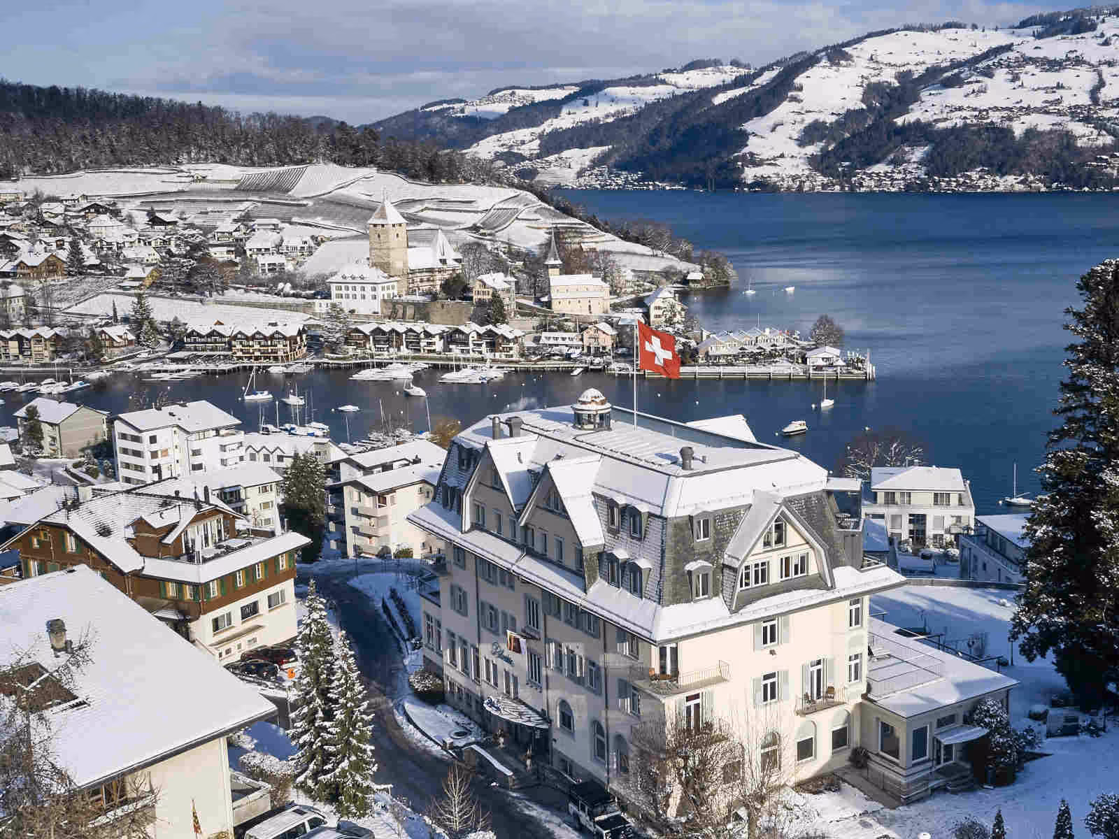 Spiez Bay and Belvédère Strandhotel covered in snow in winter