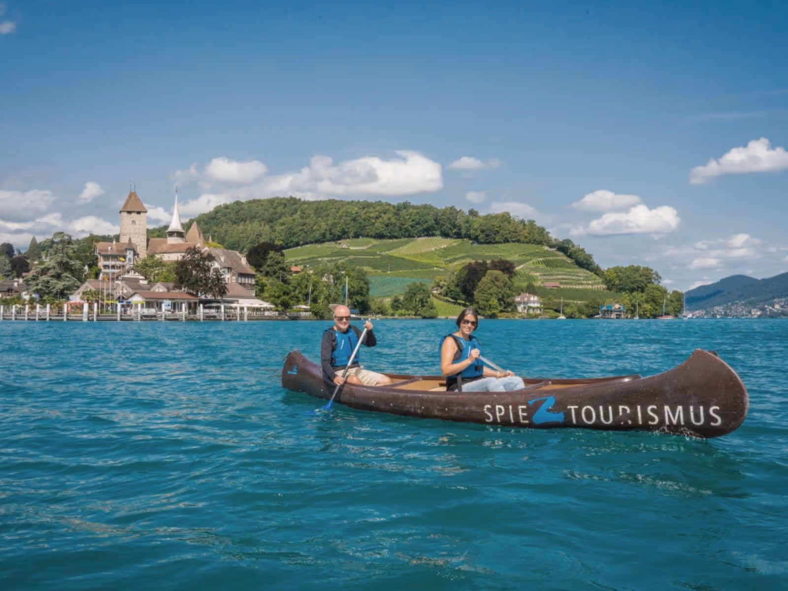 People in a canoe on Lake Thun, Spiez Bay in the background