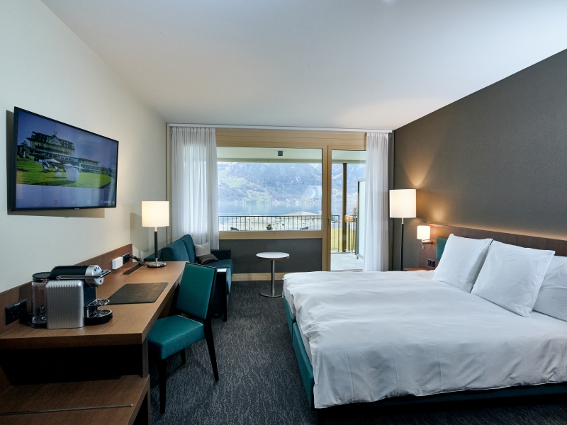 Chambre d'hôtel, chambre lumineuse avec un lit double, une fenêtre et un bureau, située dans la nouvelle aile