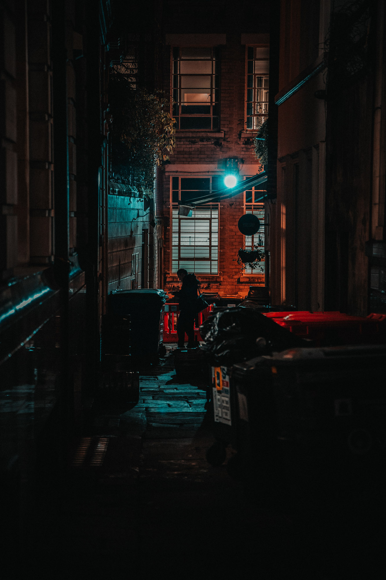 Moody scene of a person walking past an alley at night