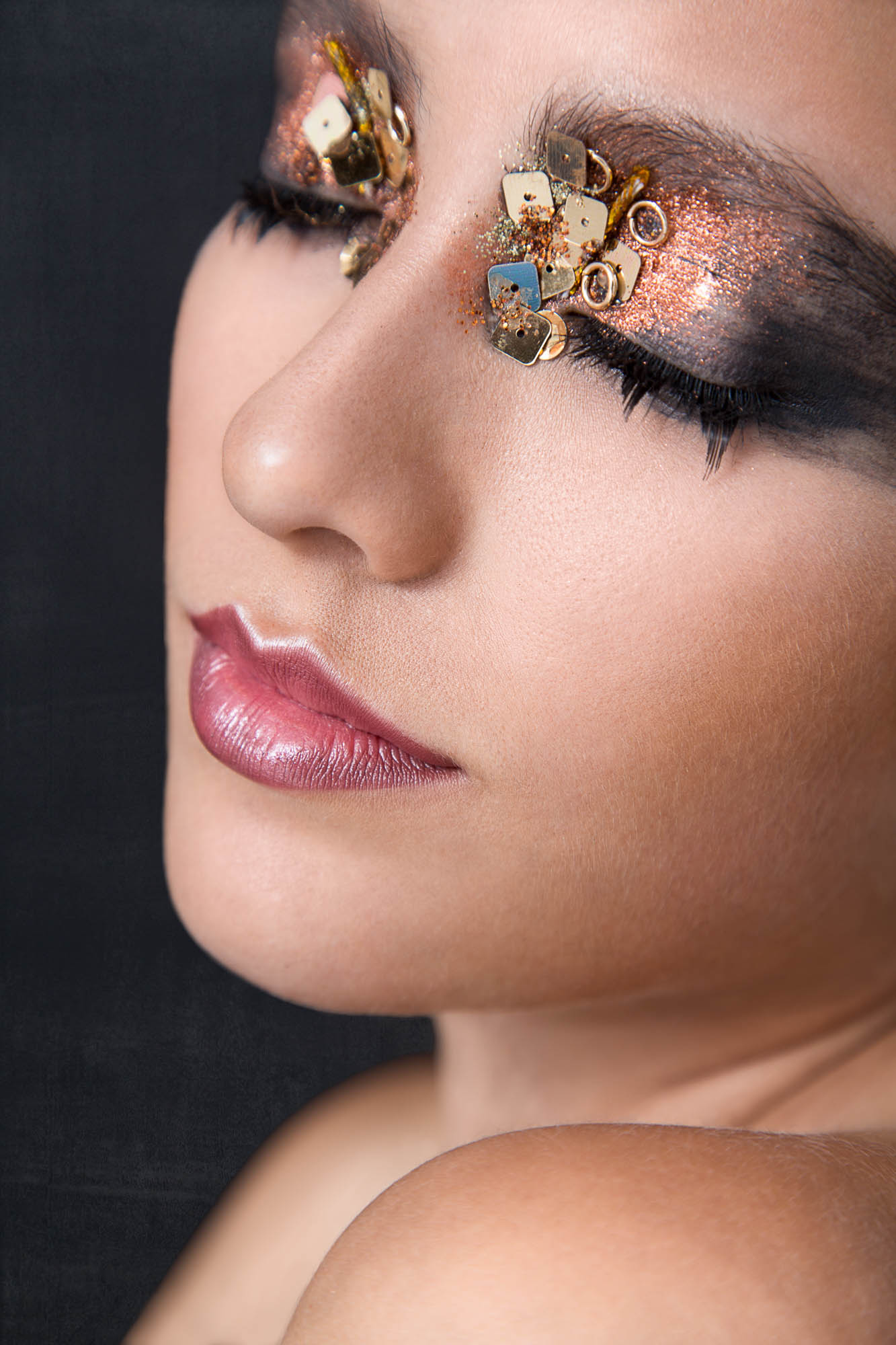 Headshot of a beauty model with extravagant make up with her eyes shut