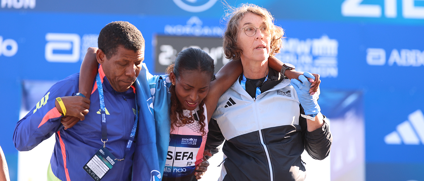 Tigst Assefa is helped away from the finish line