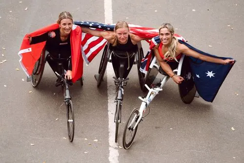 a group of athletes in wheelchairs celebrating the race finish