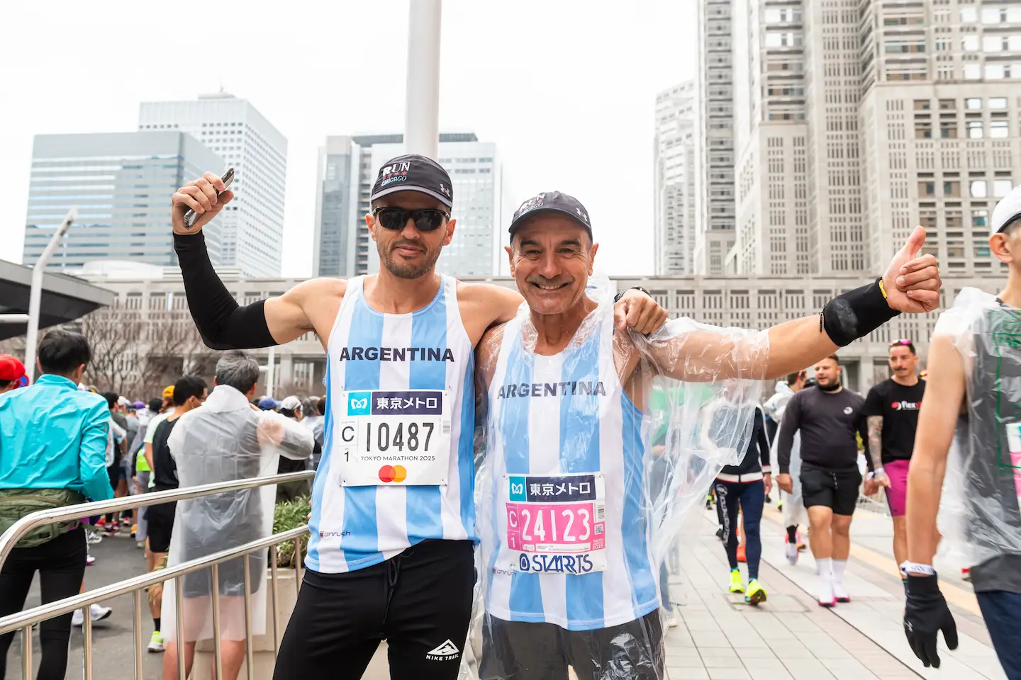 Two male runners in Argentina jerseys posing together at Tokyo Marathon finish area.