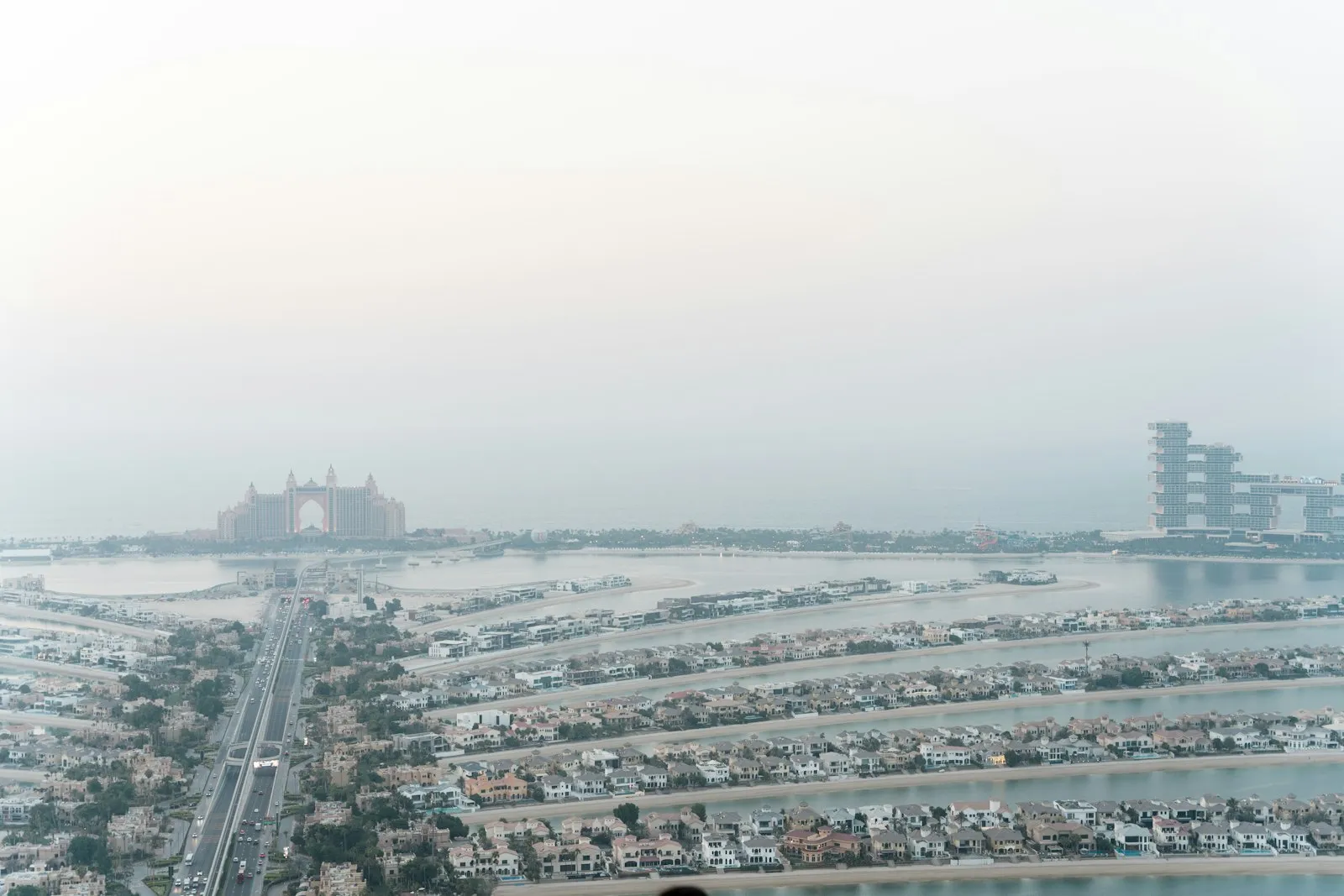 Aerial view of Palm Jumeirah villas on the Fronds, with Atlantis The Palm and Atlantis The Royal on the Crescent, Dubai
