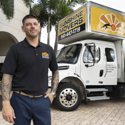 Blake Fitzpatrick standing beside a Sunshine Movers truck