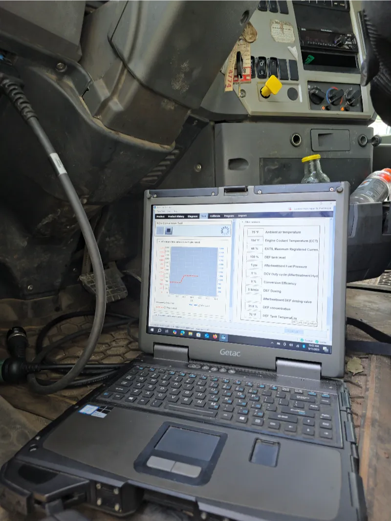 Aftertreatment diagnostics with Getac laptop running “NOx Conversion Test” inside heavy-duty truck cab.