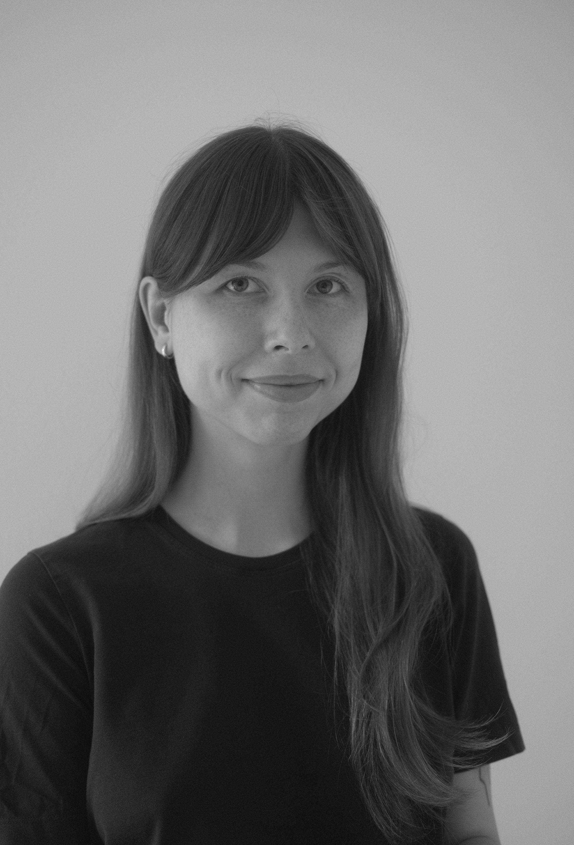 Black and white headshot of Lisa, smiling at the camera