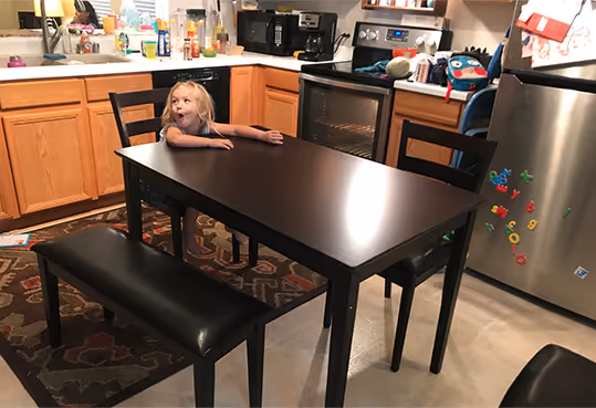 image of excited child oat the dinig room table
