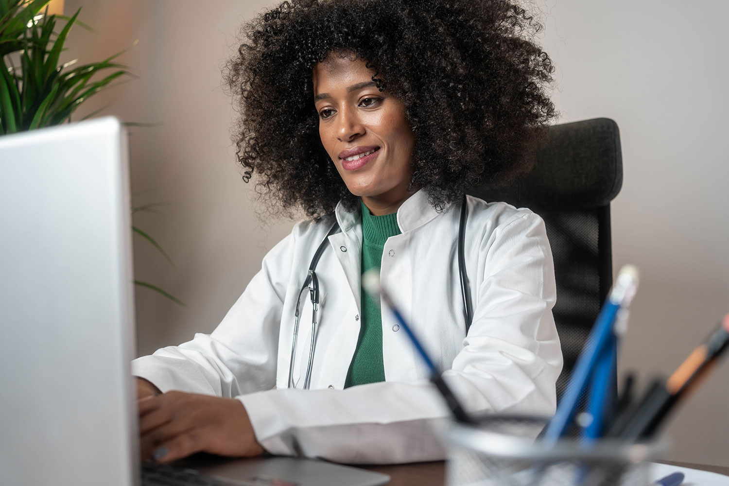 Young doctor working on laptop using Rehab Guru