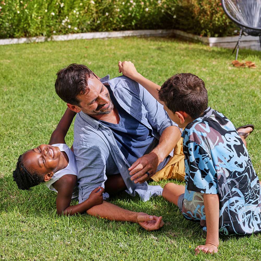 Happy father playing with his children in the garden