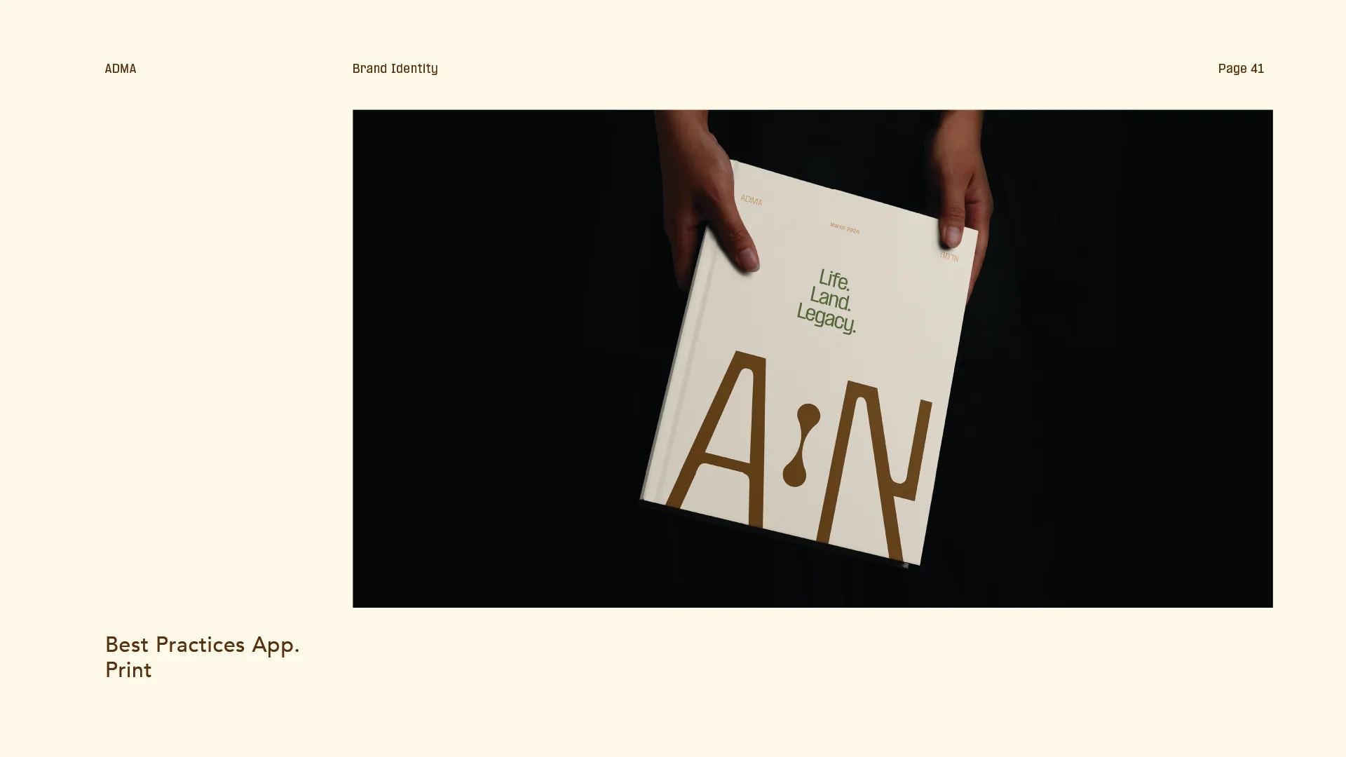 Two hands holding a book titled 'Life. Land. Legacy.' with large stylized letters A and N on the cover against a black background.