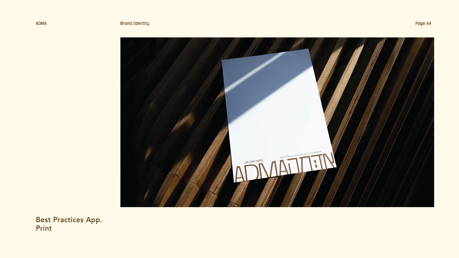 White ADMA branded paper on textured wooden surface with shadow cast across.