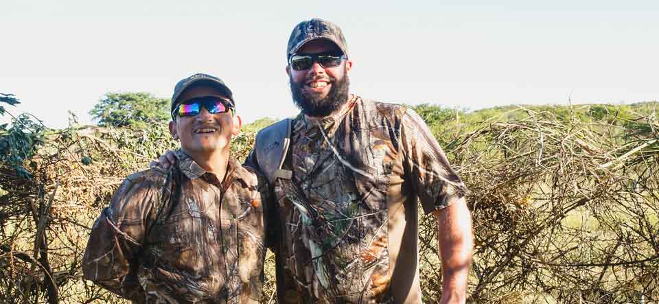 Two guest hunters posing together in the field