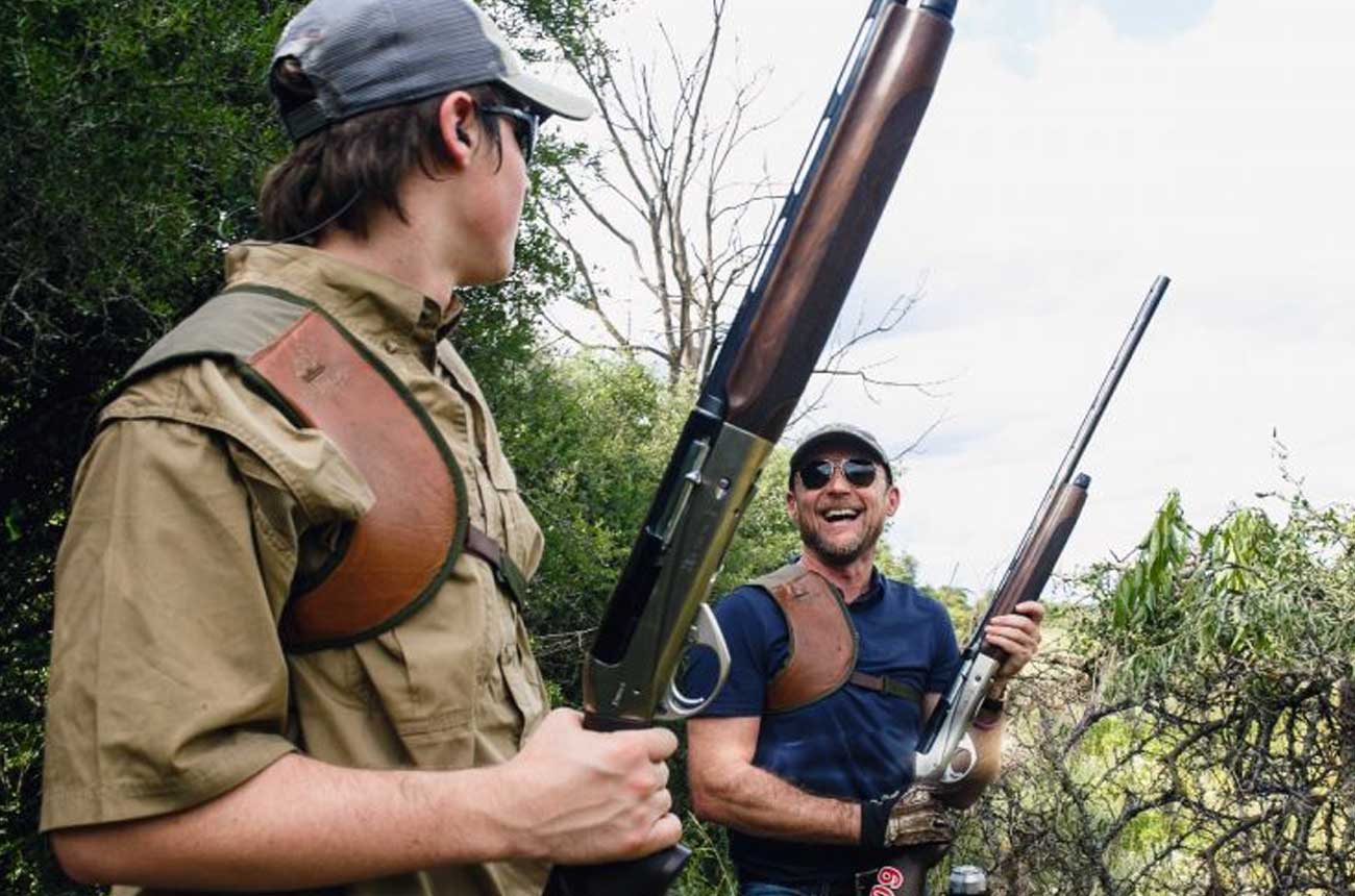 Hunter with a shell bag and guide in the dove field