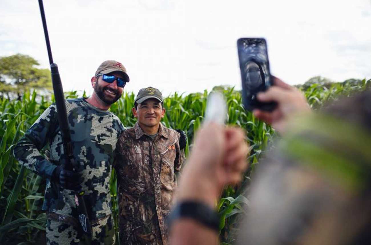 Hunter and guide checking the shot count on a phone