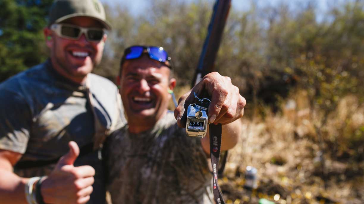 Two smiling hunters giving a thumbs-up in the field
