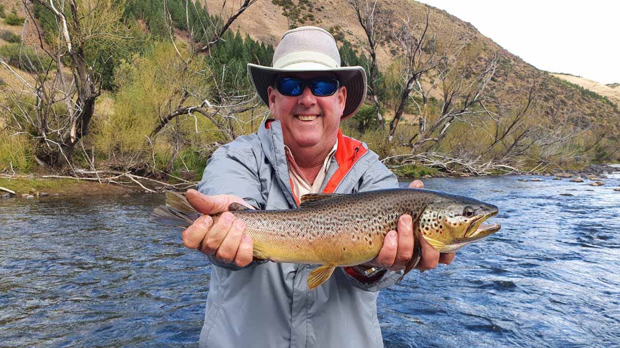 Angler with a big brown trout in Patagonia