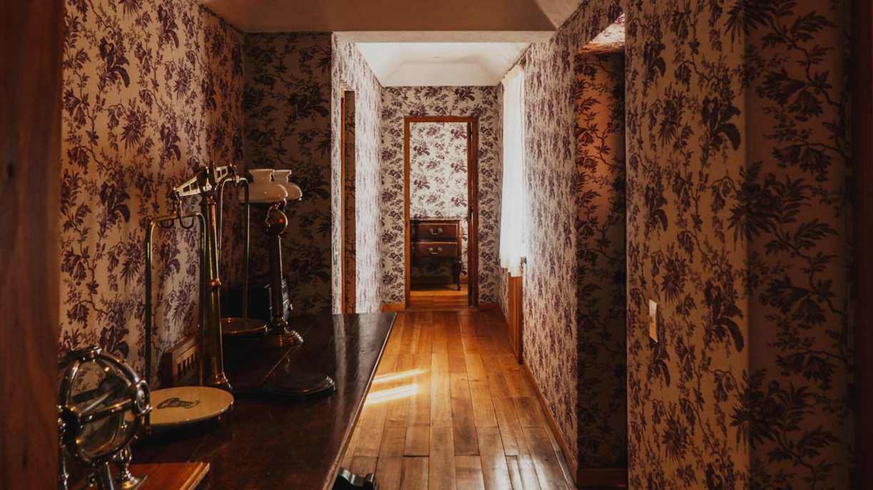 Hallway with floral wallpaper at Bravo Sur Lodge